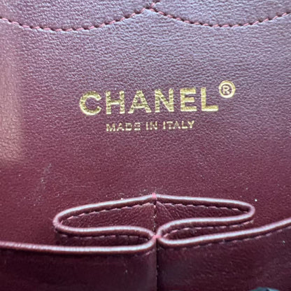 Close-up of a dark burgundy leather Chanel bag interior with gold foil CHANEL branding and 'MADE IN ITALY' text.
