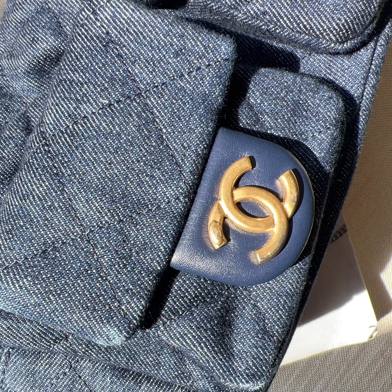 Close-up of a blue fabric with a gold logo on a textured surface