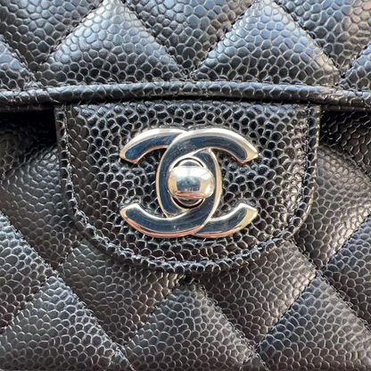 Close-up of a black quilted handbag with the Chanel logo.