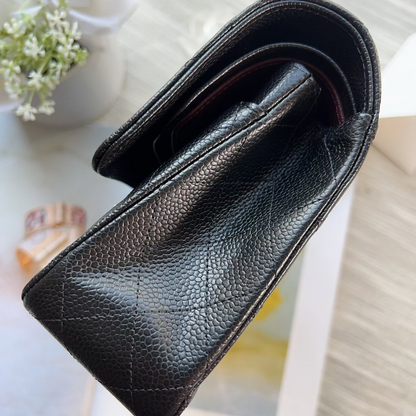 Black leather wallet on a light surface with flowers in the background