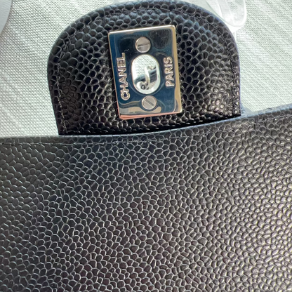 Black textured Chanel pouch with logo on a light gray background