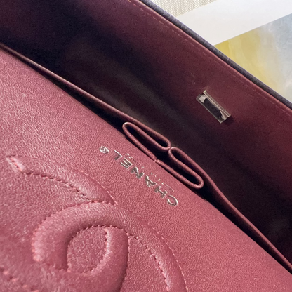 Close-up of a burgundy handbag with 'Chanel' branding.