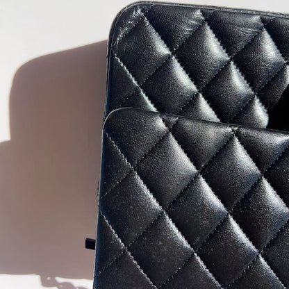 Black quilted leather bag on a light gray background