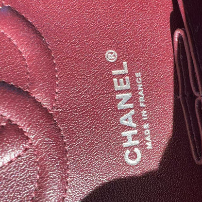 Close-up of a Chanel logo on a red leather product.