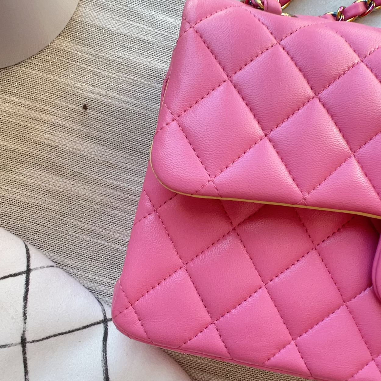Pink quilted handbag on a textured surface