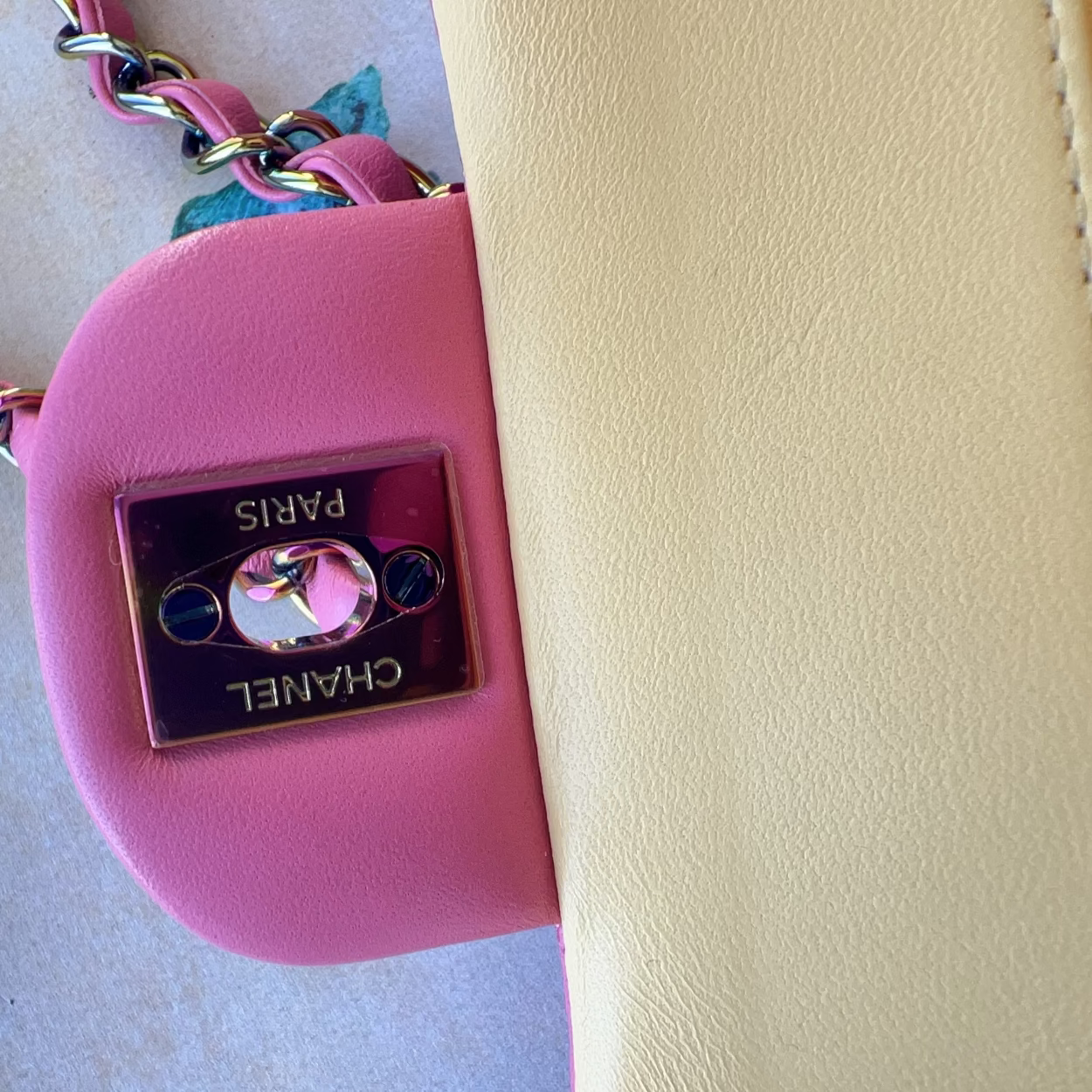 Pink handbag with gold chain strap on a light background