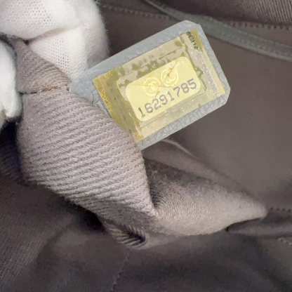 Close-up of a gold tag with numbers on a gray fabric background