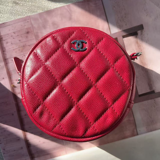 Red quilted Chanel purse on a wooden surface
