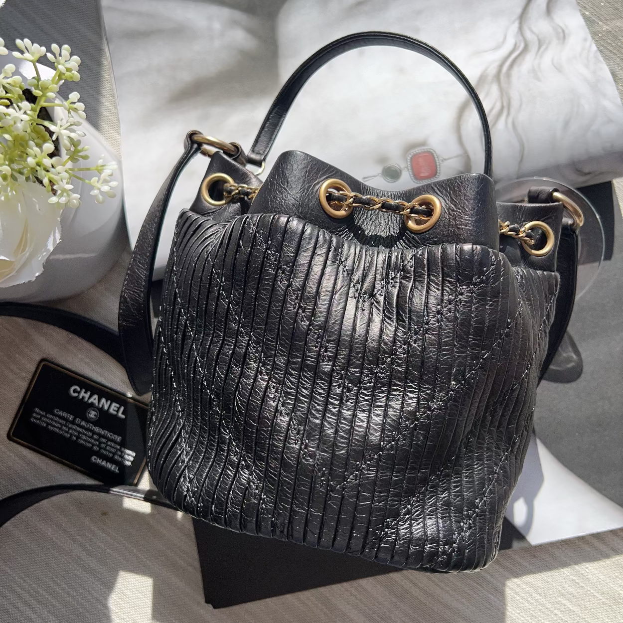 Black textured handbag with gold hardware on a magazine