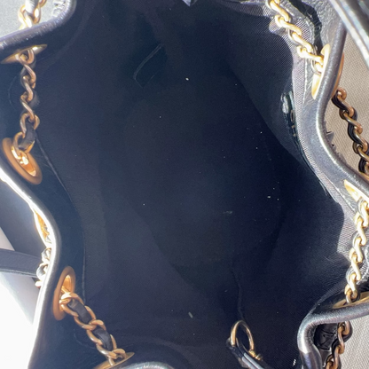 Close-up of a black handbag with gold chain details