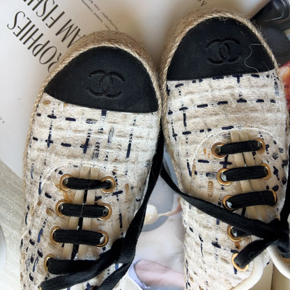 Pair of Chanel sneakers on a magazine with visible branding.
