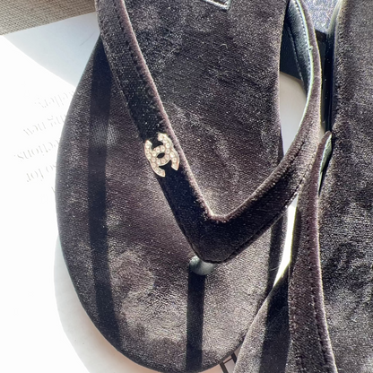 Pair of Chanel sandals on a white surface with a blurred background