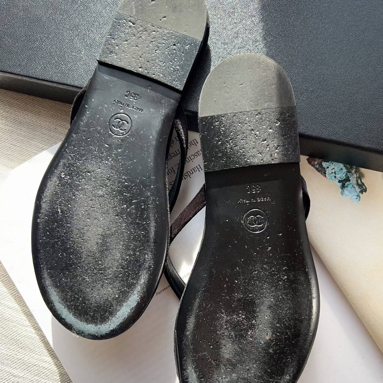 Close-up of black shoe soles with Chanel logo on a branded box background