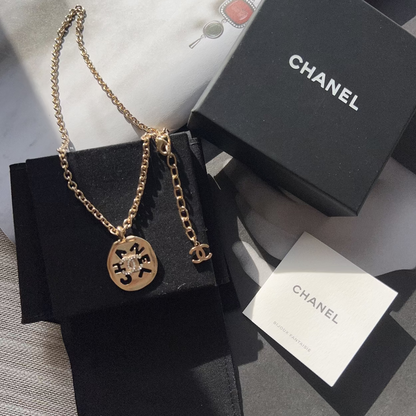 Chanel necklace with chain on a black box with Chanel branding