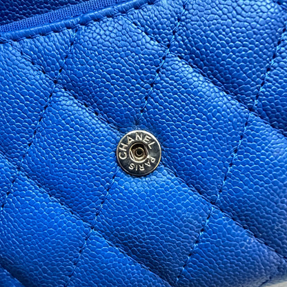 Close-up of a blue quilted handbag with a Chanel logo.