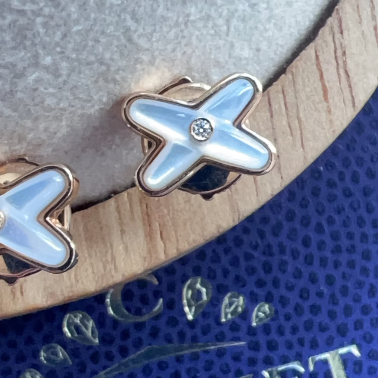 Star-shaped earrings with a blue center on a textured surface