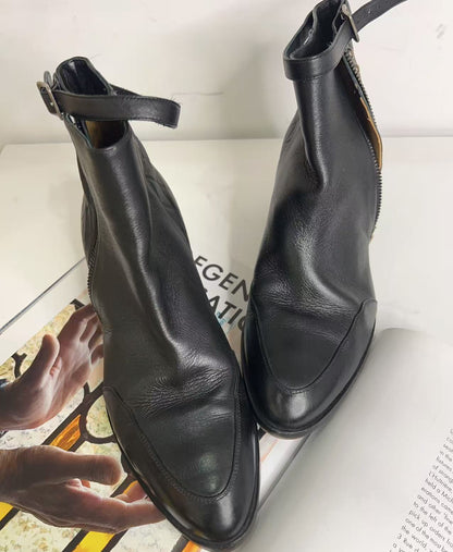 Pair of black leather ankle boots on a magazine