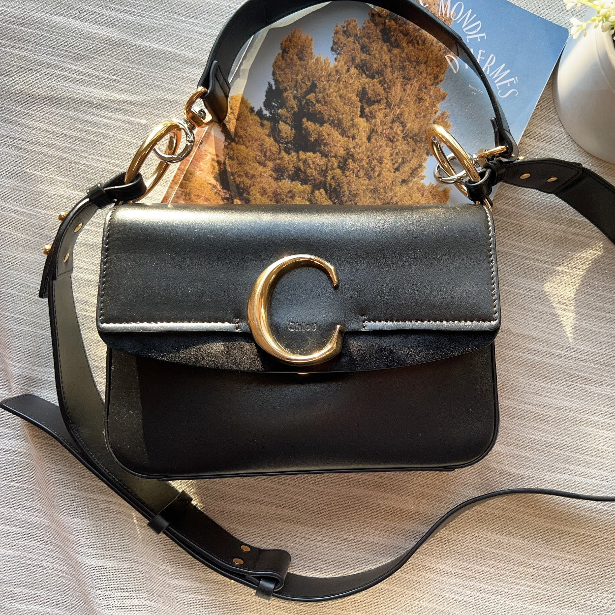 Black handbag with gold accents on a wooden surface