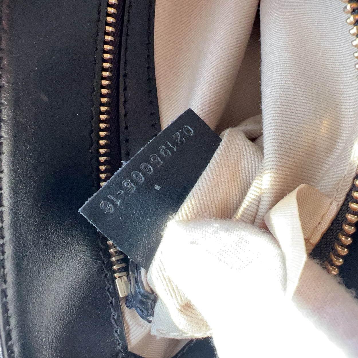 Close-up of a black leather bag with a visible brand tag.
