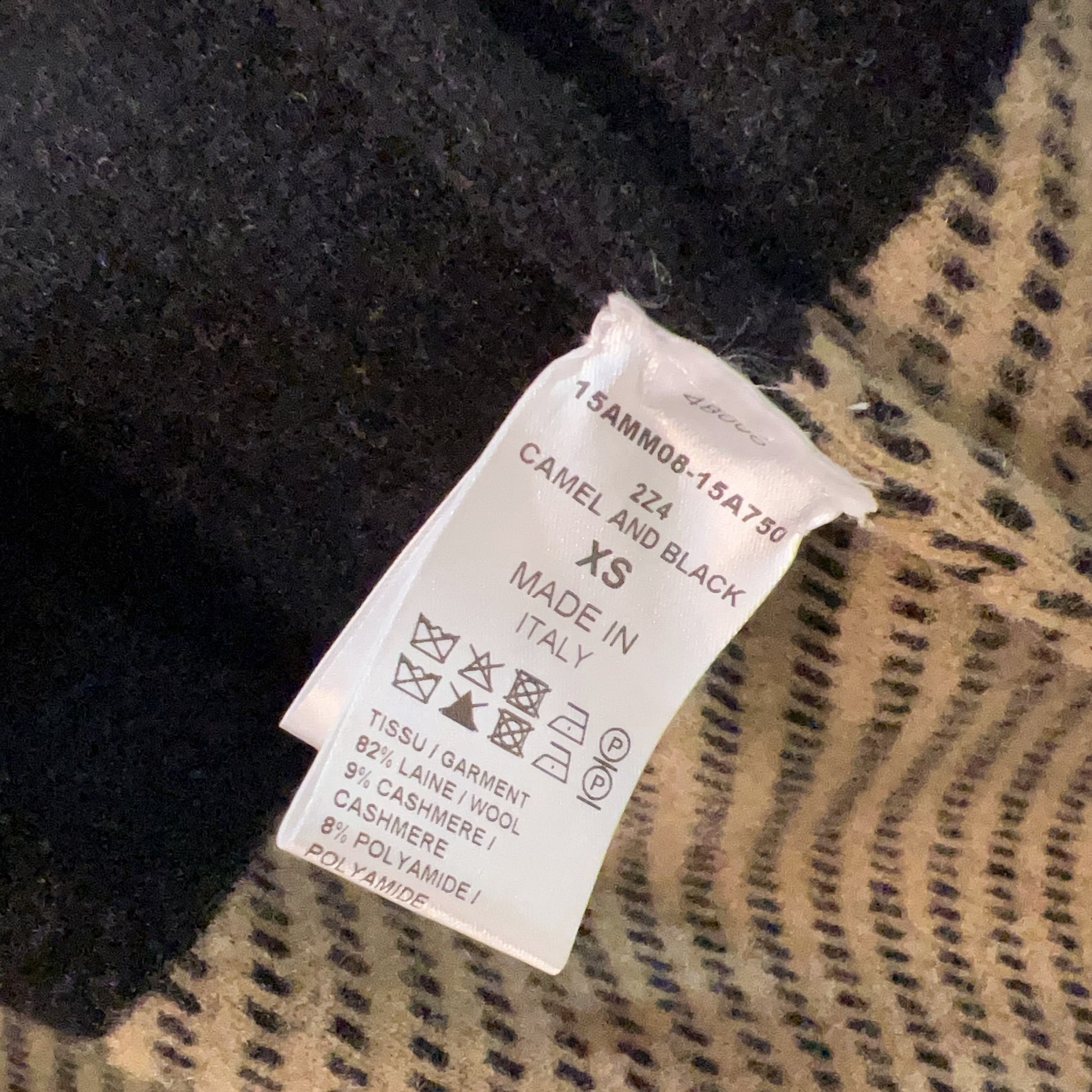 Clothing tag on a black and beige patterned fabric