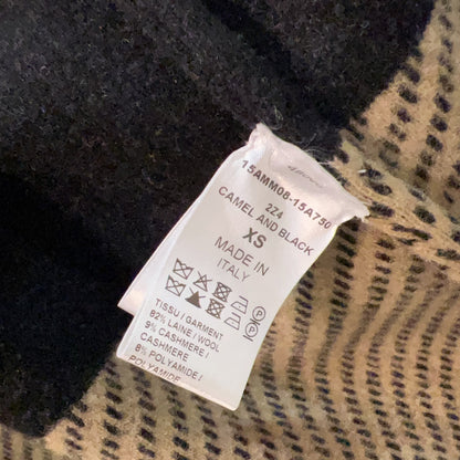 Clothing tag on a black and beige patterned fabric