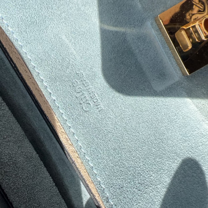 Close-up of a textured surface with a gold lock and visible brand name.