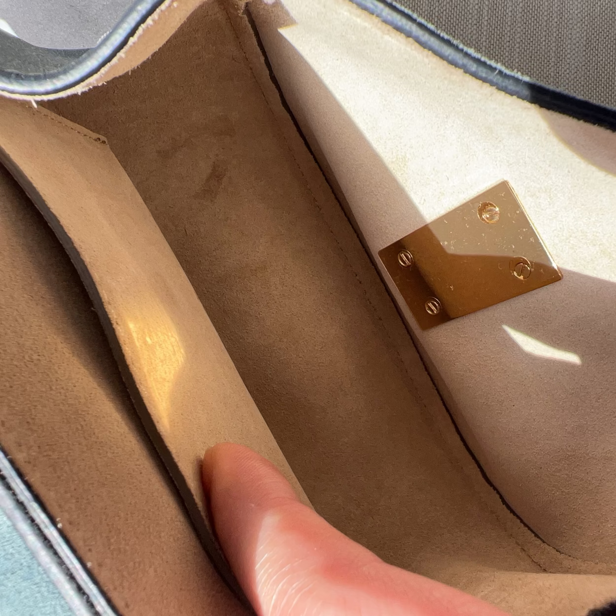 Close-up of a suitcase interior with a hand opening it