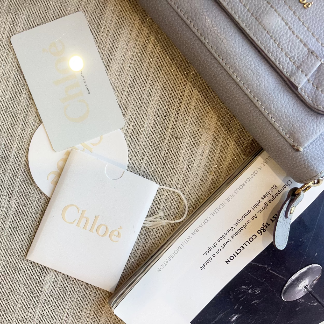 Chloe handbag with branded pouch and card on a textured surface