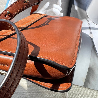 Close-up of a brown leather handbag with a blurred background