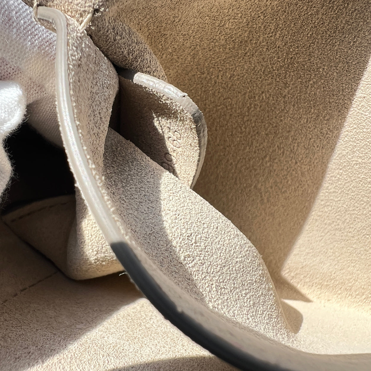 Close-up of a sand-covered car seat with a clear plastic cover.