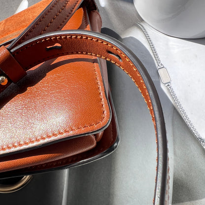 Close-up of a brown leather saddle on a metallic surface