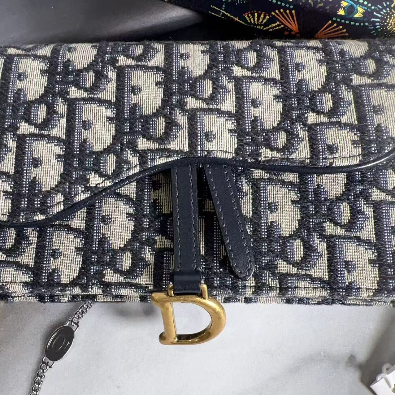 Designer handbag with distinctive pattern and gold clasp on a marble surface