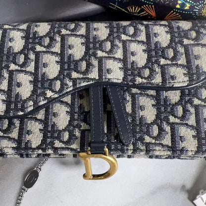 Designer handbag with distinctive pattern and gold clasp on a marble surface