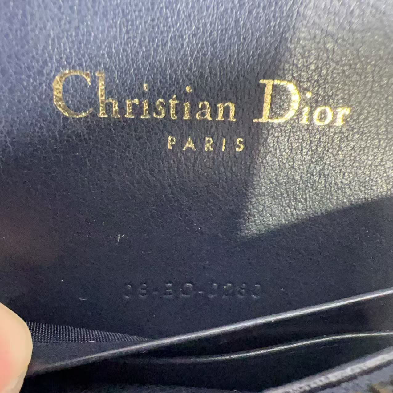 Close-up of a Christian Dior wallet with gold lettering.