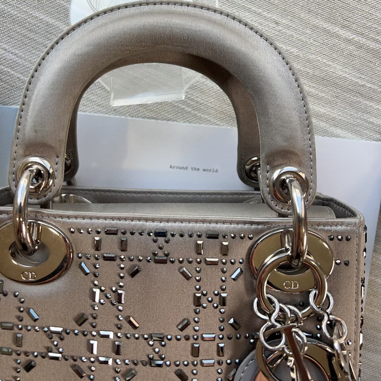 Designer handbag with gold hardware and chain detail on a neutral background