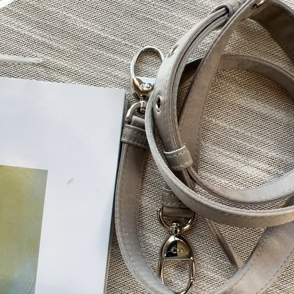 Close-up of a beige handbag with a strap on a textured surface