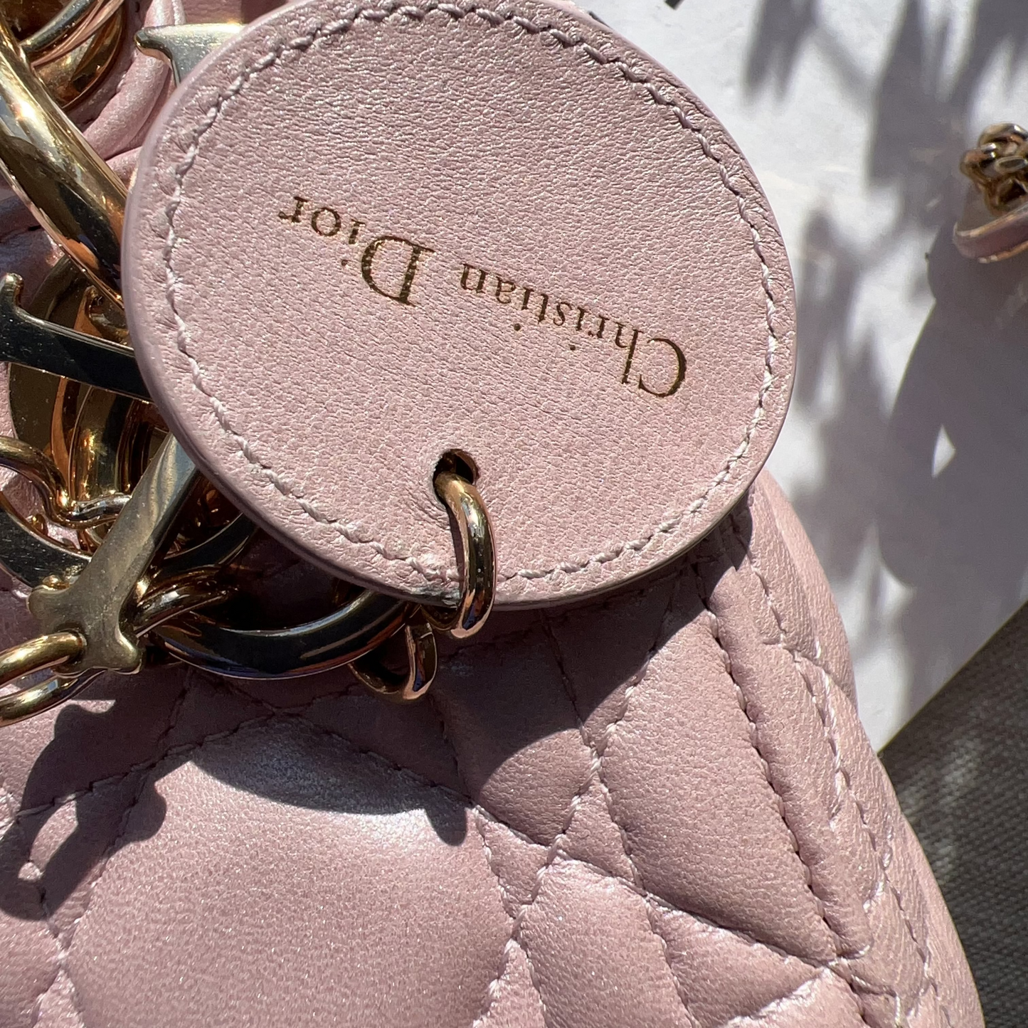 Pink leather keychain with gold chain on a pink textured surface, brand 'Chinatown Market' visible.