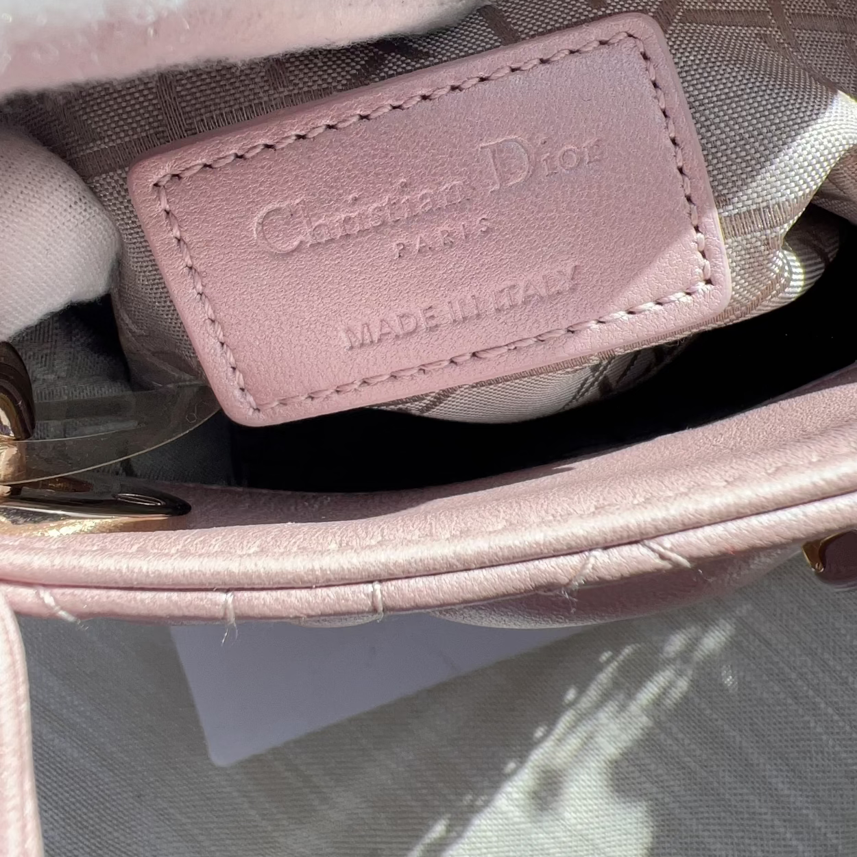 Close-up of a pink Dior handbag with a visible brand label.