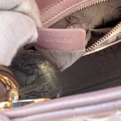 Close-up of a pink handbag with visible brand logo.