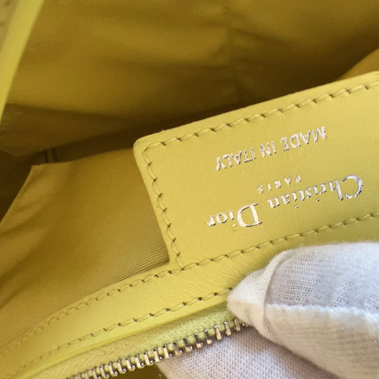 Close-up of a yellow Christian Dior bag with visible branding.