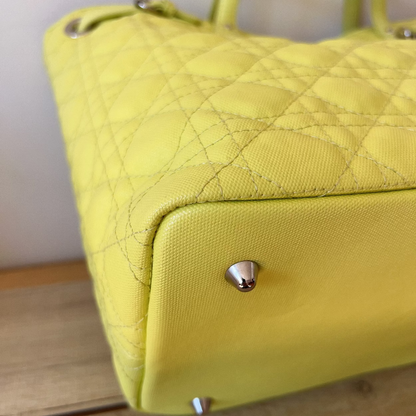 Yellow quilted handbag on a wooden surface