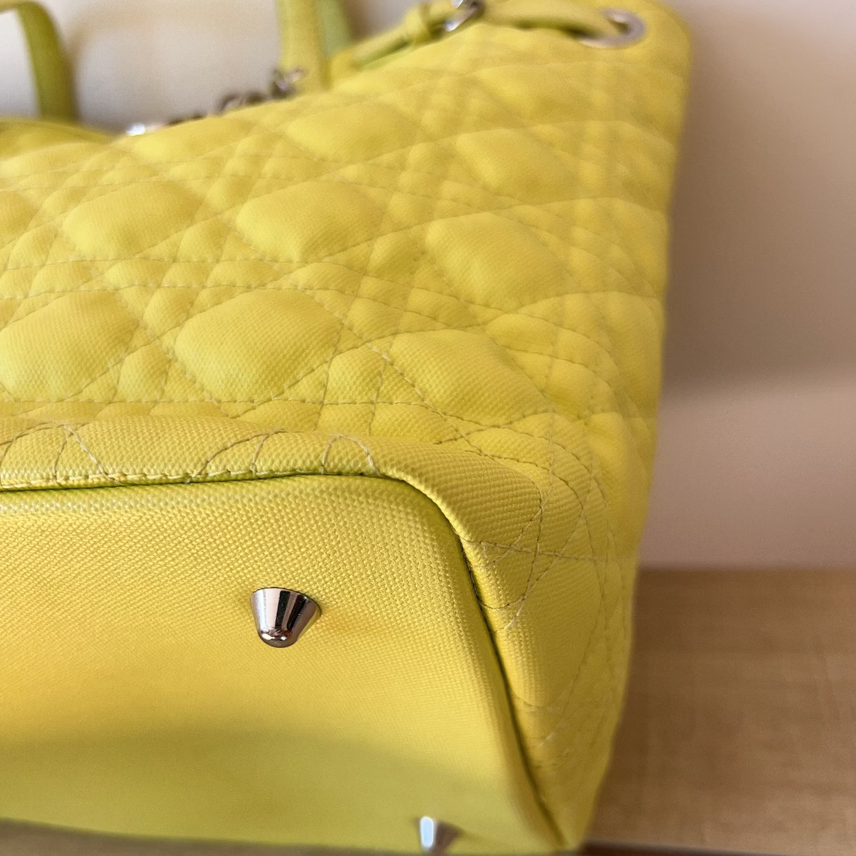 Yellow quilted handbag on a wooden surface