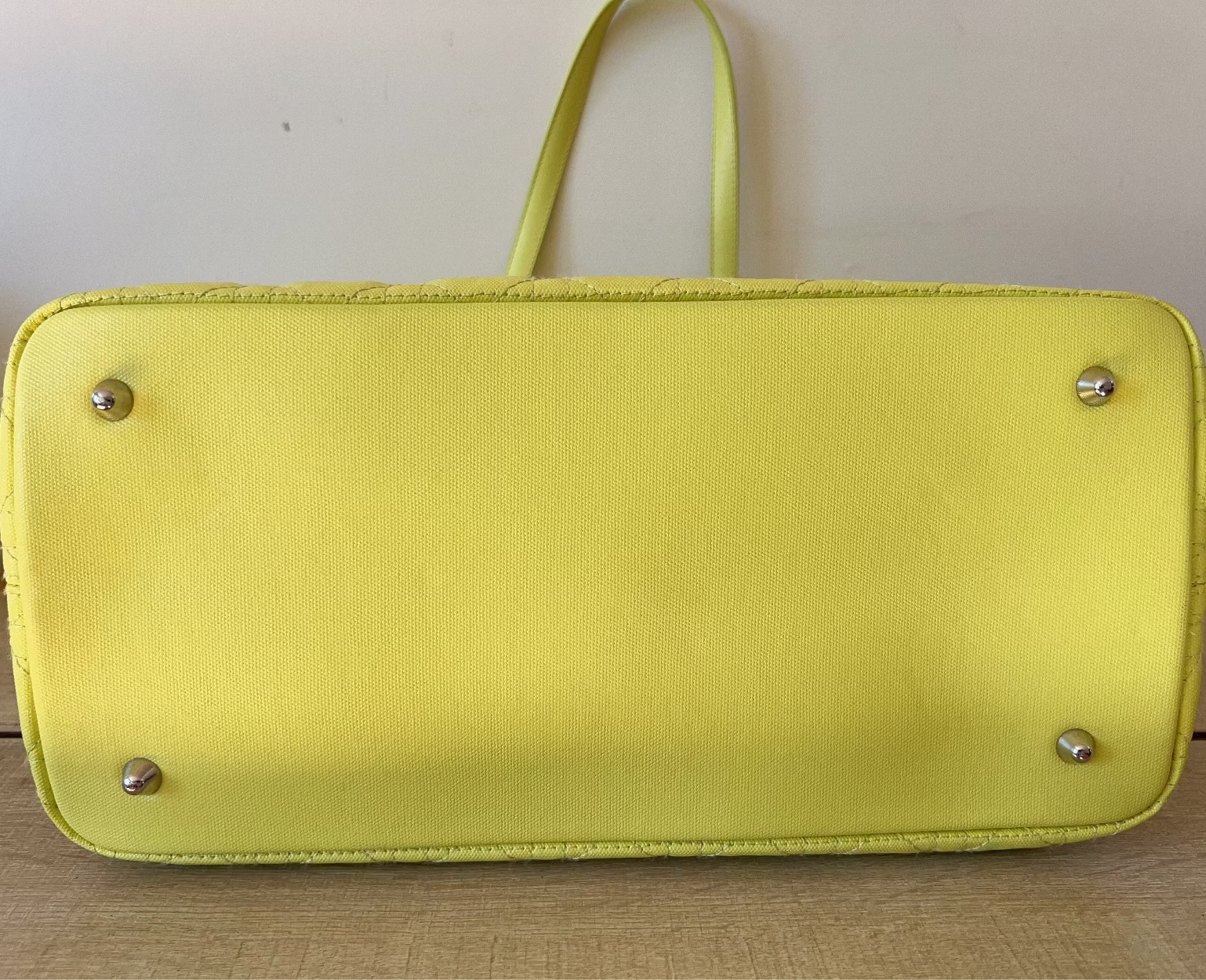 Yellow handbag with silver studs on a wooden surface