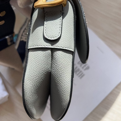 Gray leather keychain with gold clasp on a light background
