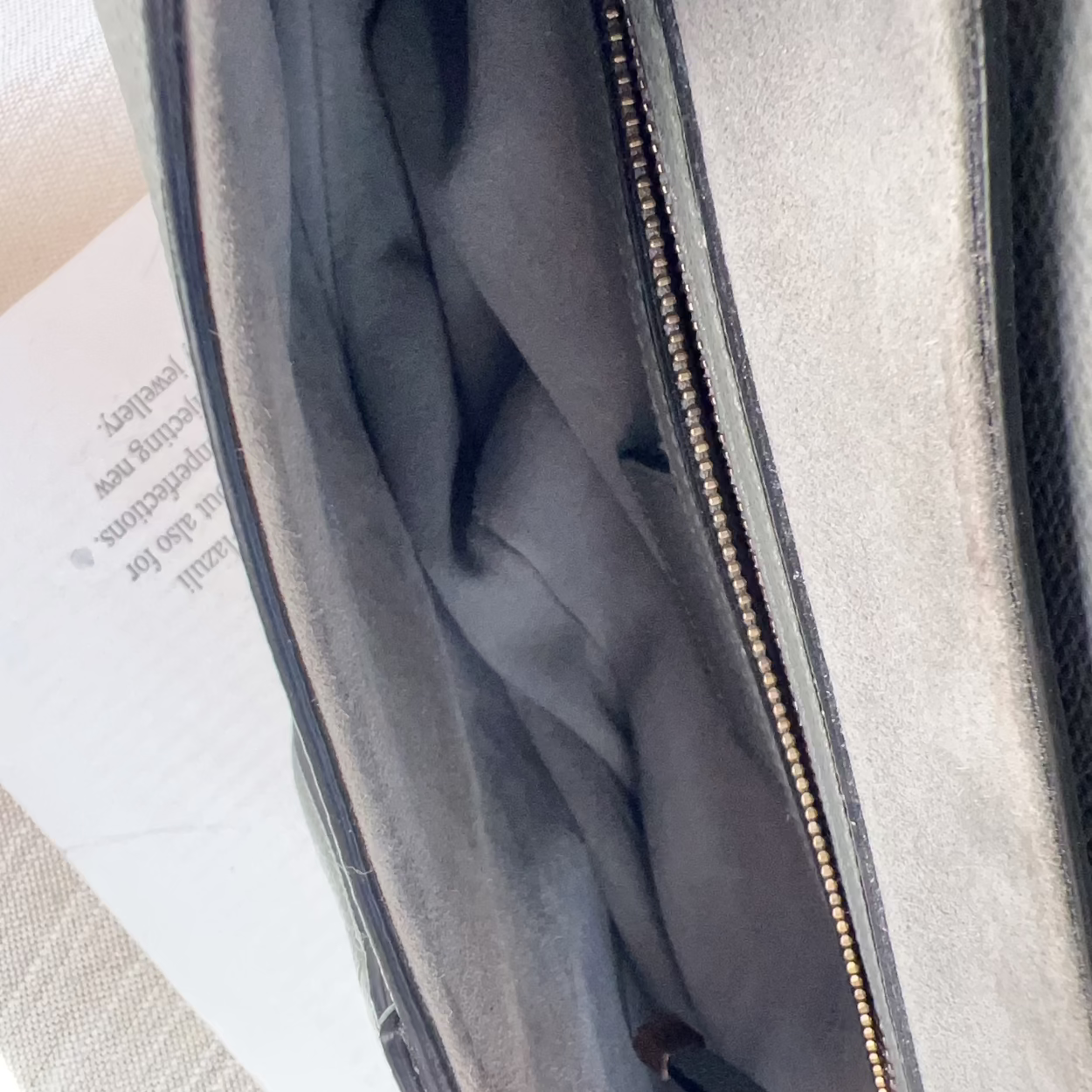 Gray laptop bag with gold zipper on a white surface