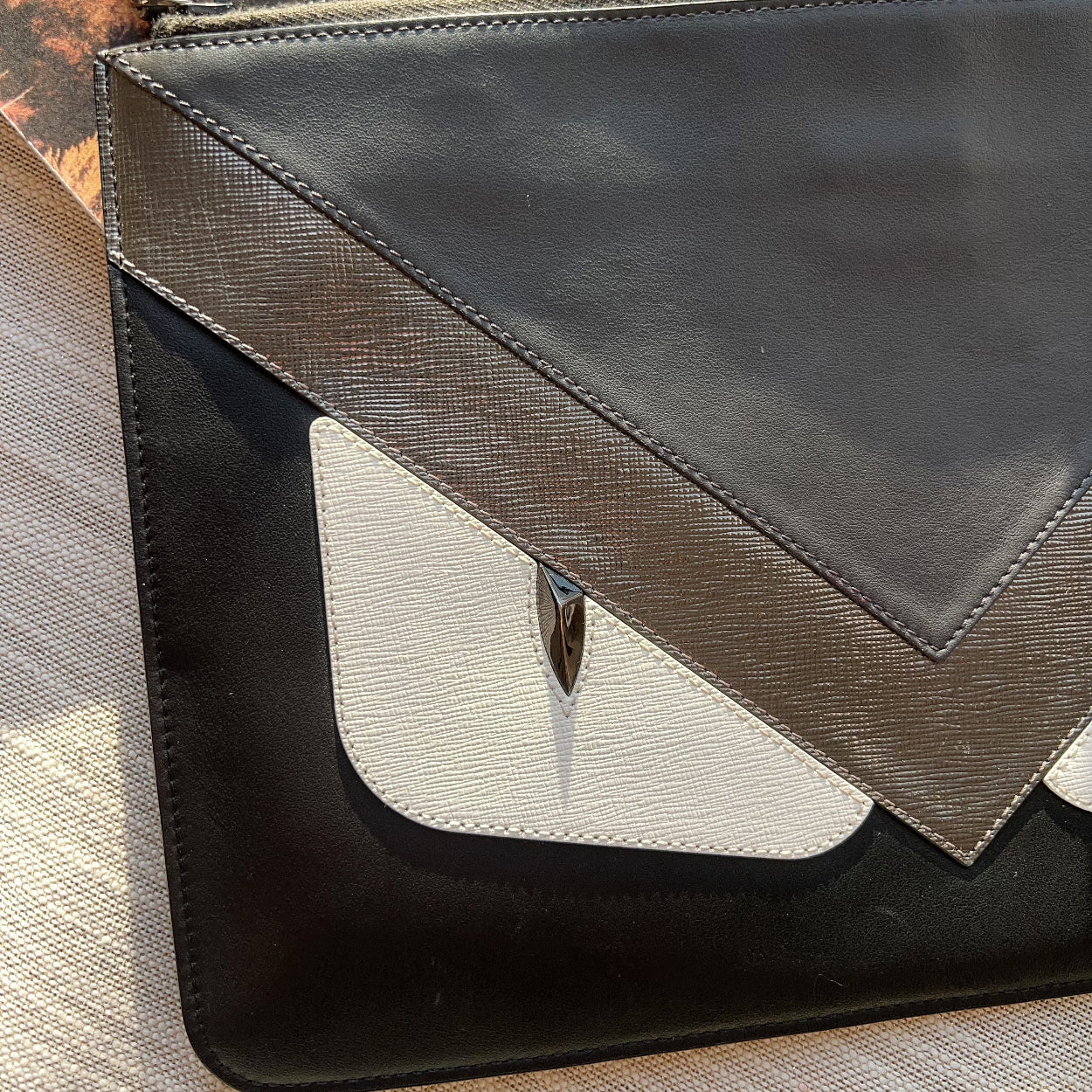 Black and gray handbag on a textured surface with blurred natural background