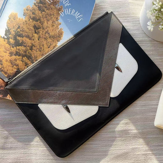 Black leather wallet on a textured surface with a Fendi bag in the background