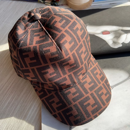 Brown patterned cap on a textured surface with a blurred background