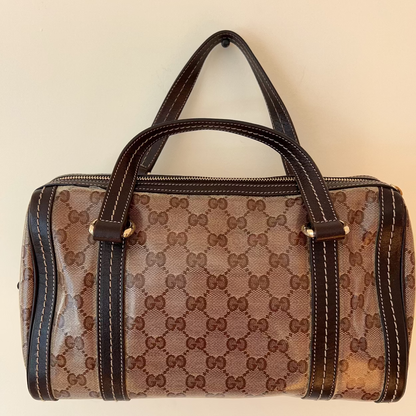 Designer handbag with a prominent brand logo on a beige background