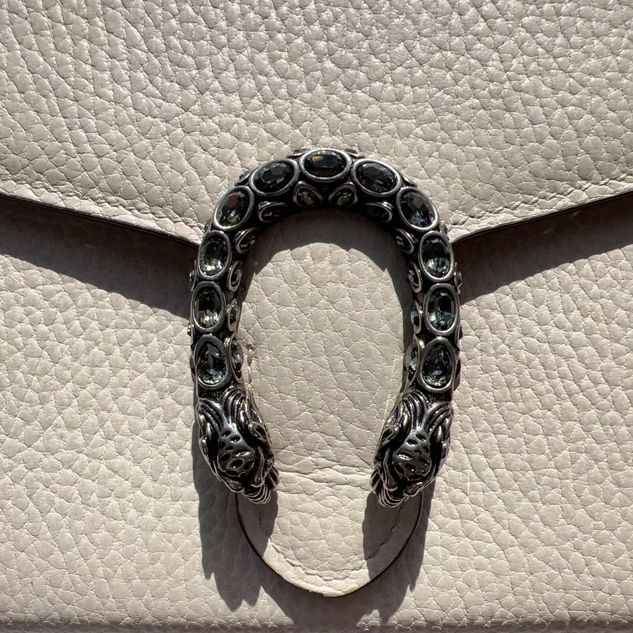 Decorative metal bracelet on a textured beige surface